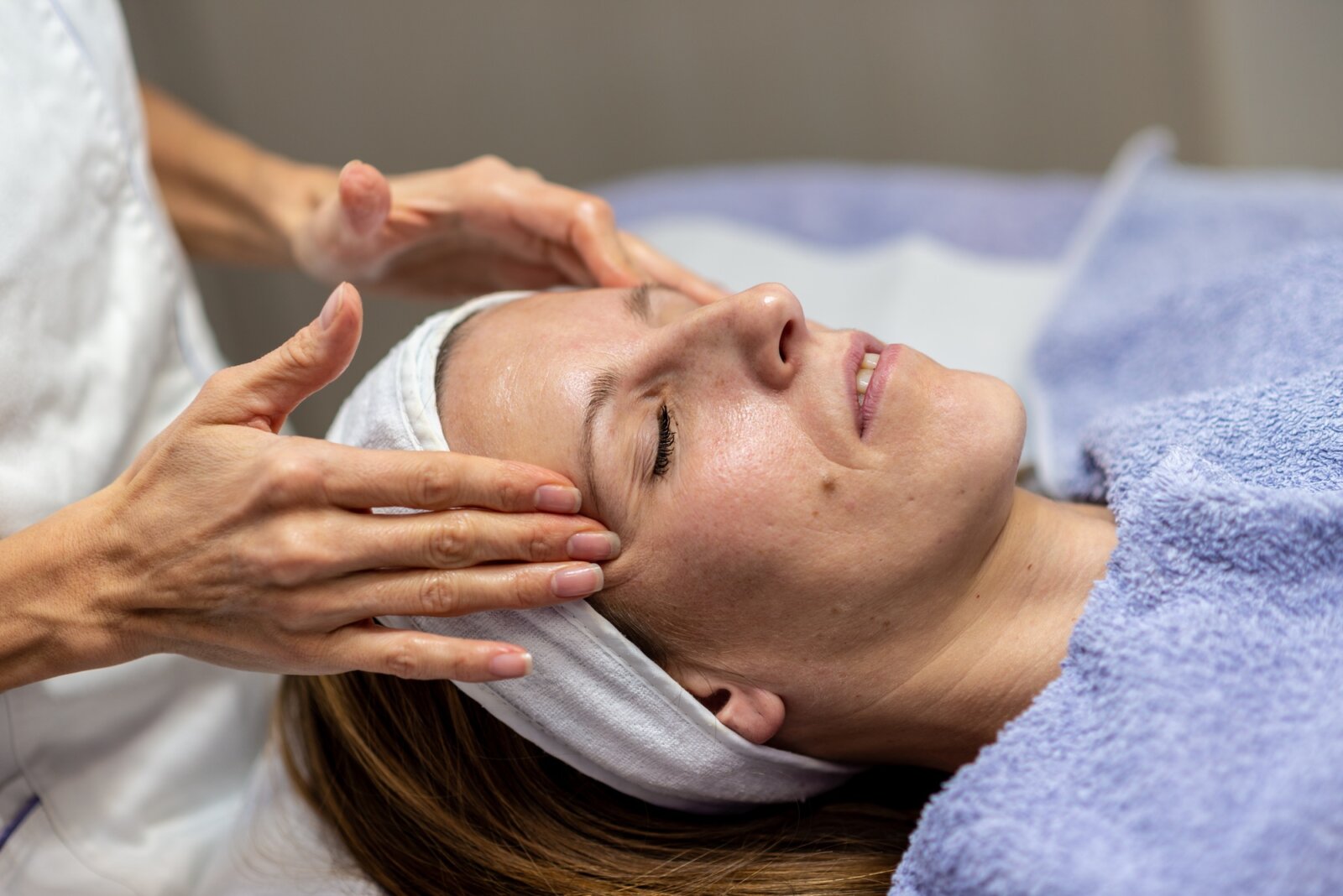 Young brunette enjoying cleansing facial massage